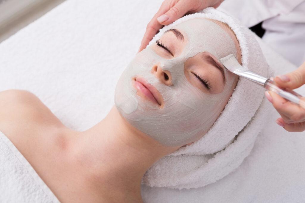 Woman gets face mask by beautician at spa › Hellenic Laser Spa A woman receiving professional facial treatments in Denver